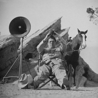 Movie Director George Stevens Holding Up a Rangefinder as He Directs Scene for the Movie "Giant"